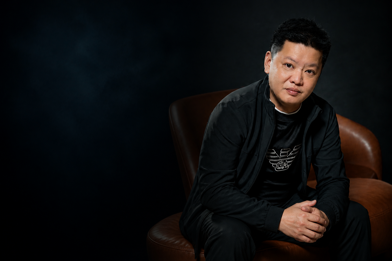 Master Xing Yi seated beside a traditional Chinese compass